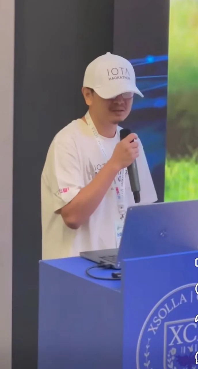 Presenter speaking with microphone at IOTA Hackathon event