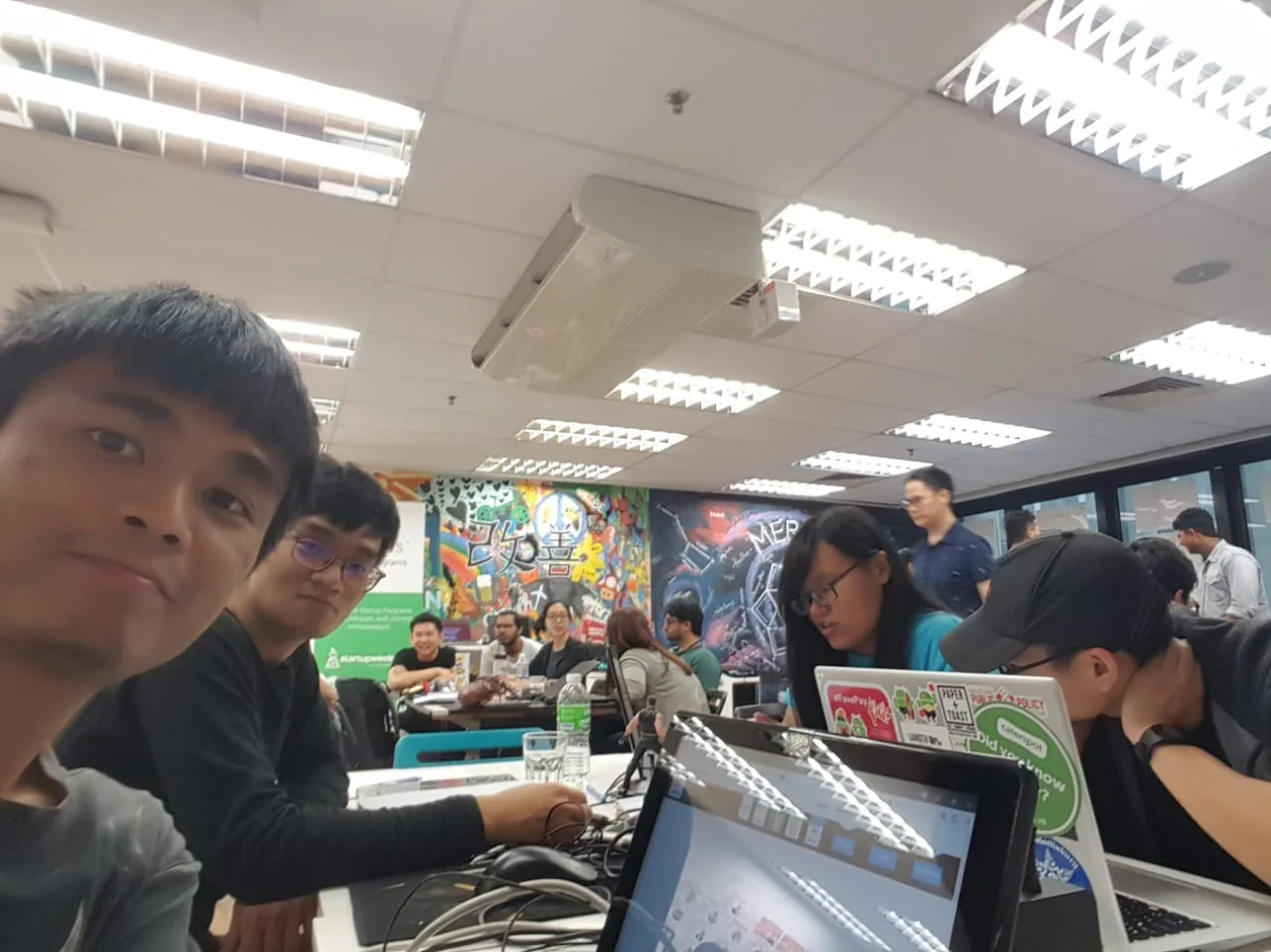 Early startup weekend team building together at laptops