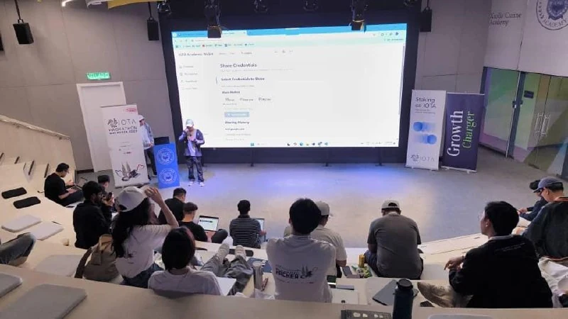 Speaker presenting on stage to an auditorium audience