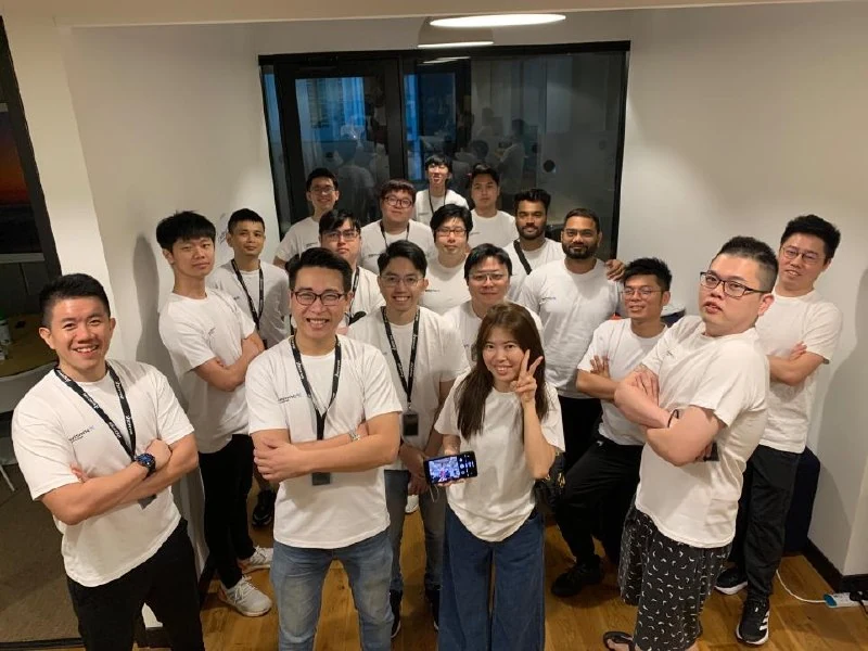 Large group photo with team members in white shirts