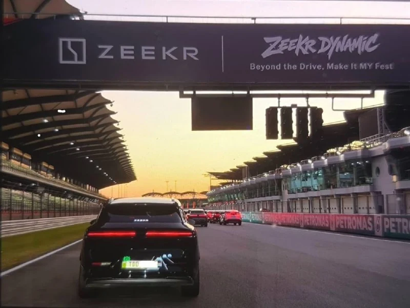 Cars driving on a racetrack under a Zeekr banner