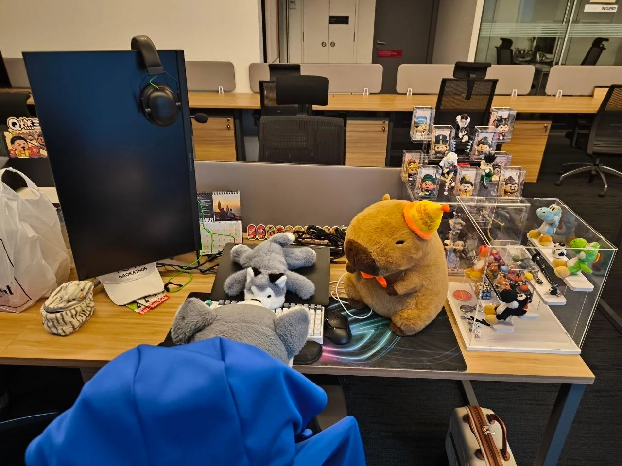 Office workstation with figurines and collectibles around the monitor