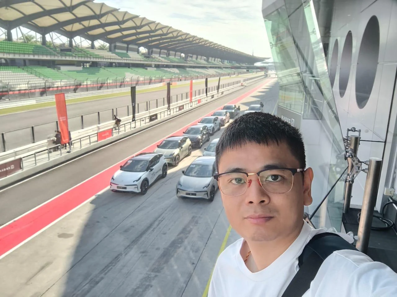 Selfie overlooking a racetrack pit lane and grandstand