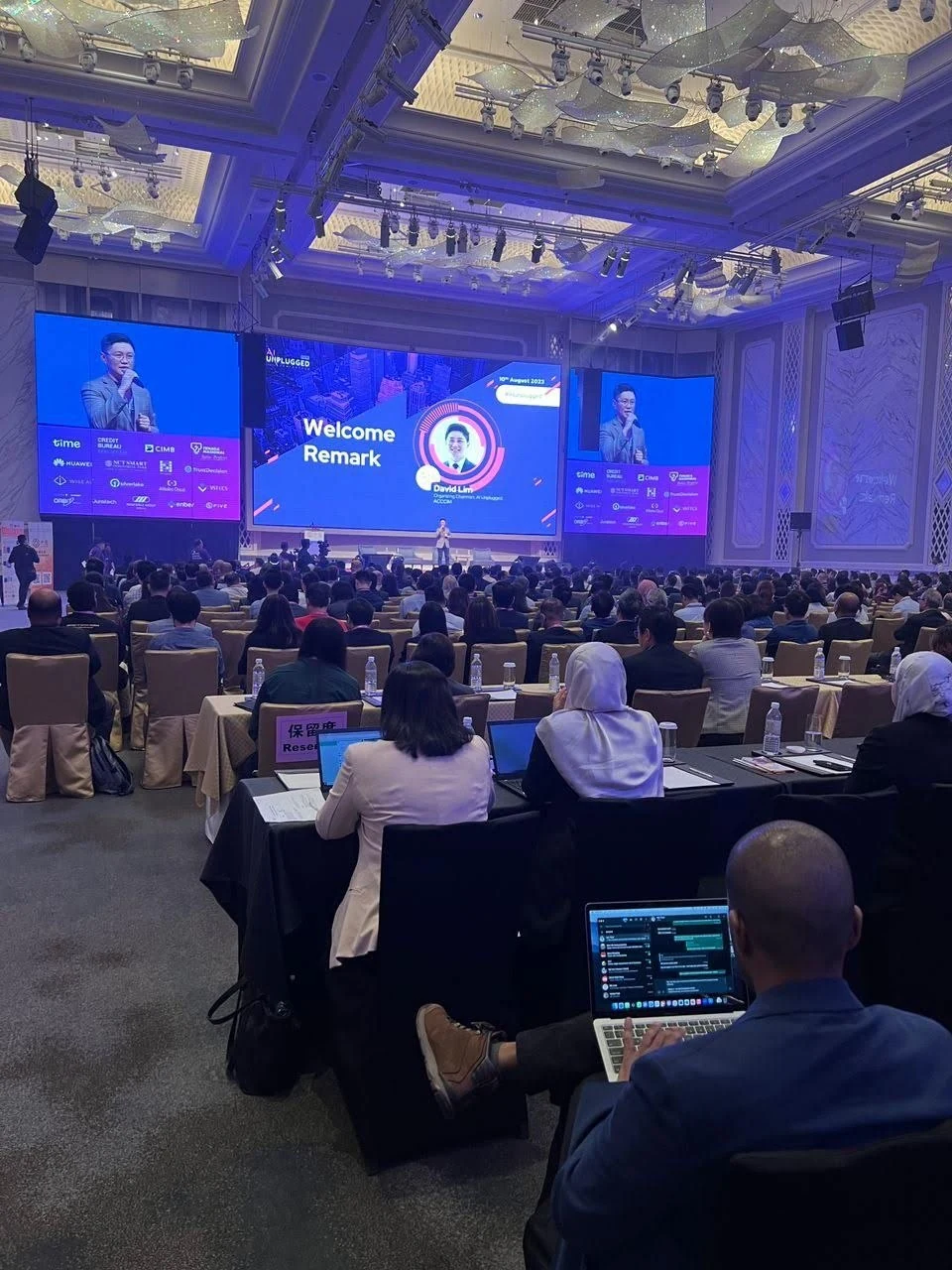 Large audience during welcome remarks on the main conference stage