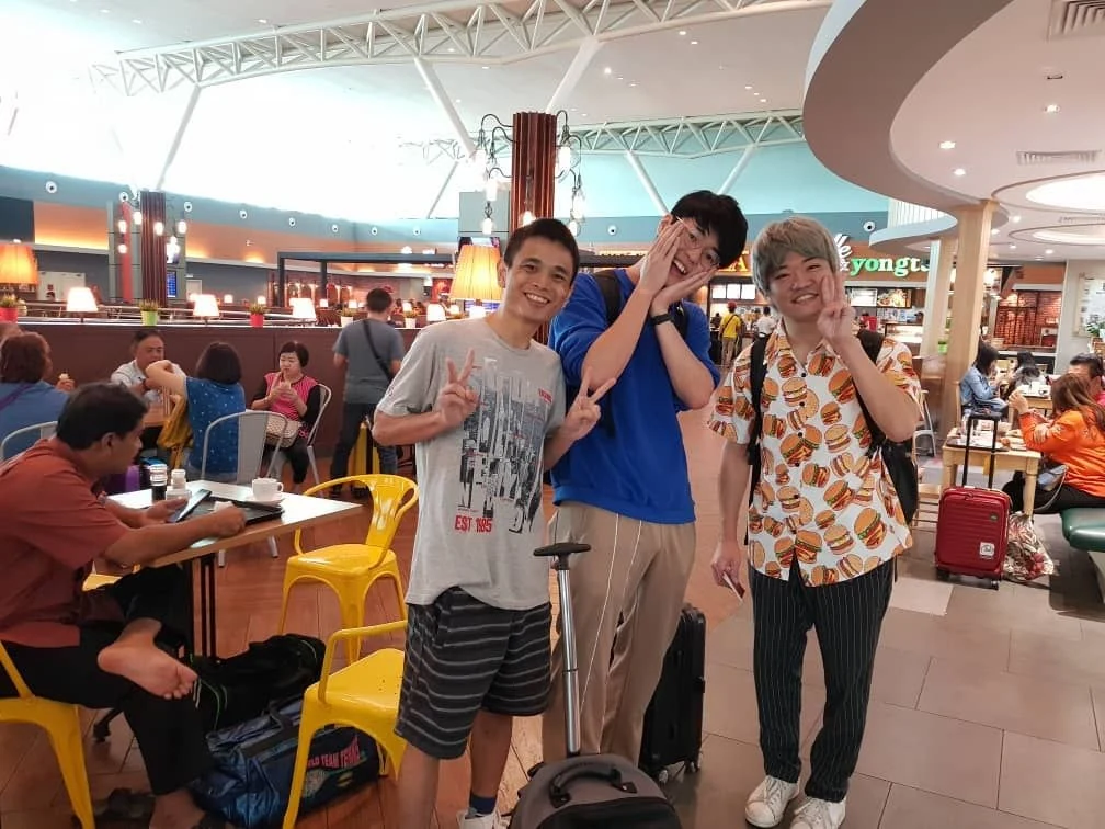 Casual group photo with luggage in a food court meetup setting